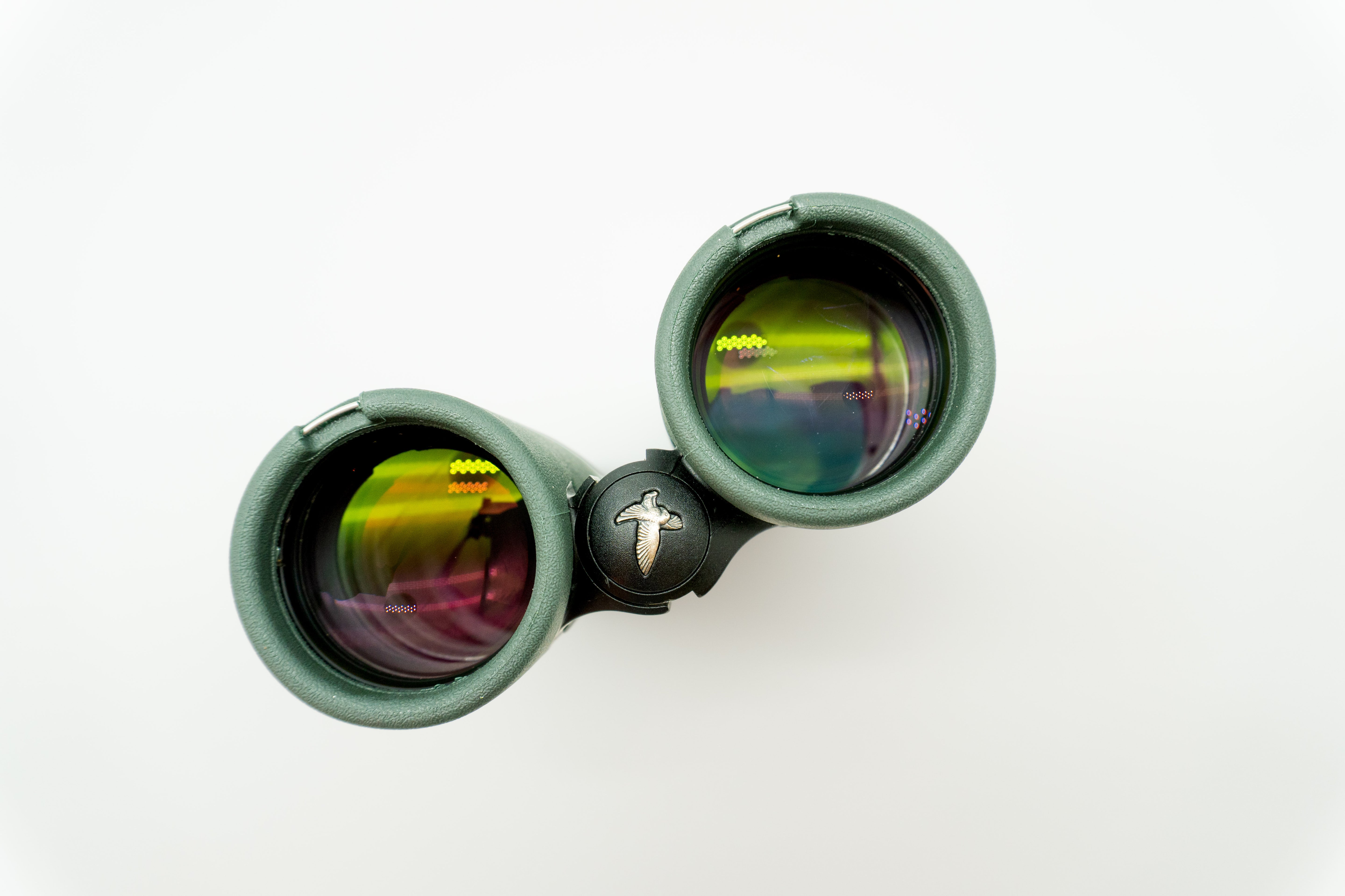 A pair of green binoculars displayed upright on a white branded stand against a clean white background.