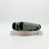 A pair of green binoculars displayed upright on a white branded stand against a clean white background.