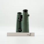 A pair of green binoculars displayed upright on a white branded stand against a clean white background.