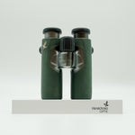 SWAROVSKI green cl pocket binoculars with white background on a stand.