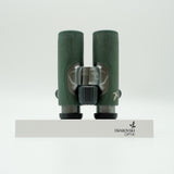 SWAROVSKI green cl pocket binoculars with white background on a stand.