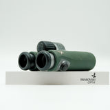 SWAROVSKI green cl pocket binoculars with white background on a stand.