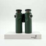 SWAROVSKI green cl pocket binoculars with white background on a stand.