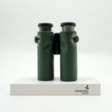 SWAROVSKI green cl pocket binoculars with white background on a stand.