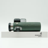 SWAROVSKI green cl pocket binoculars with white background on a stand.