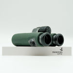 SWAROVSKI green cl pocket binoculars with white background on a stand.