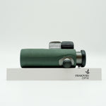 SWAROVSKI green cl pocket binoculars with white background on a stand.