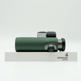 SWAROVSKI green cl pocket binoculars with white background on a stand.